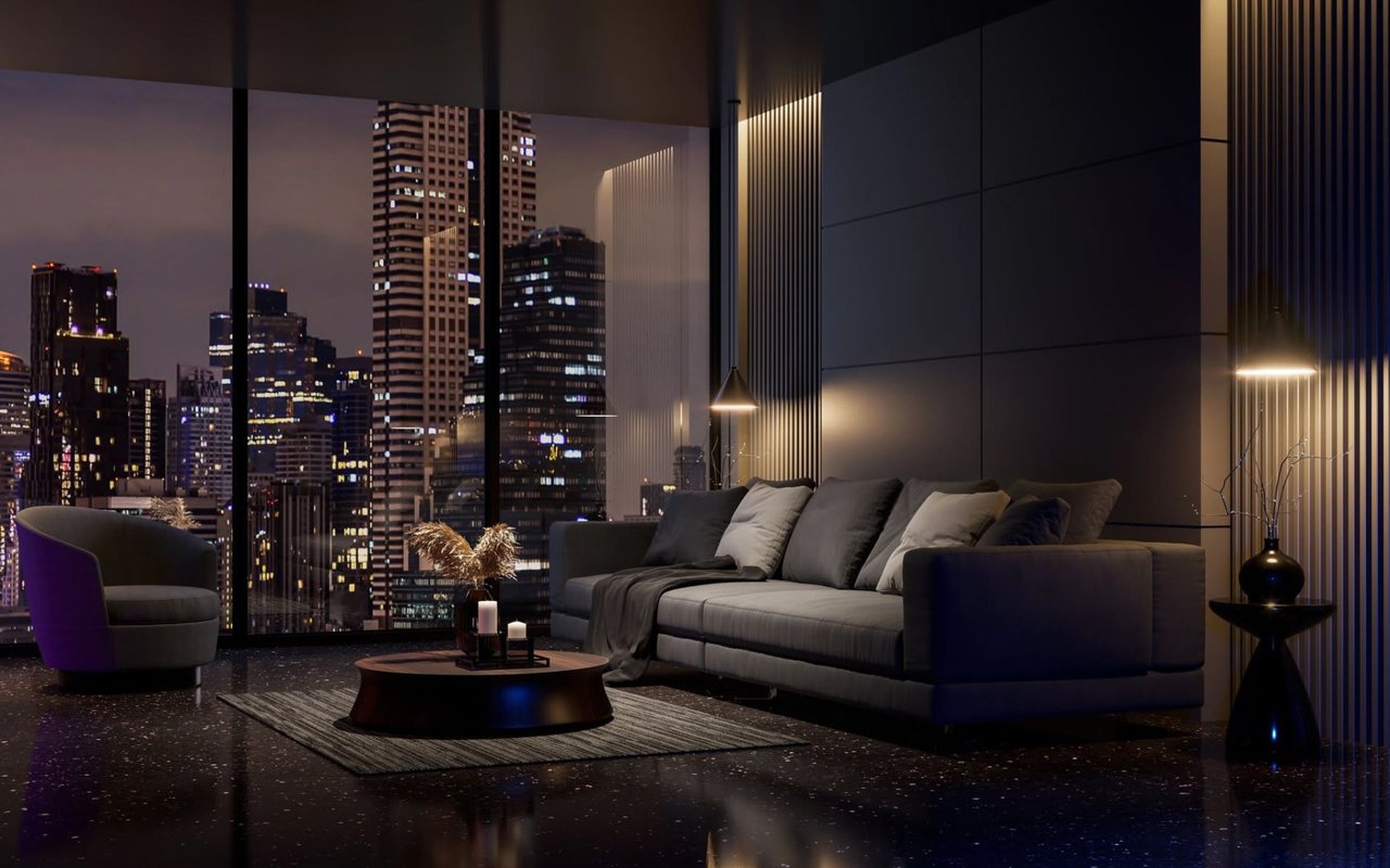 Modern living room with a gray sectional and floor-to-ceiling windows overlooking a city skyline at night.
