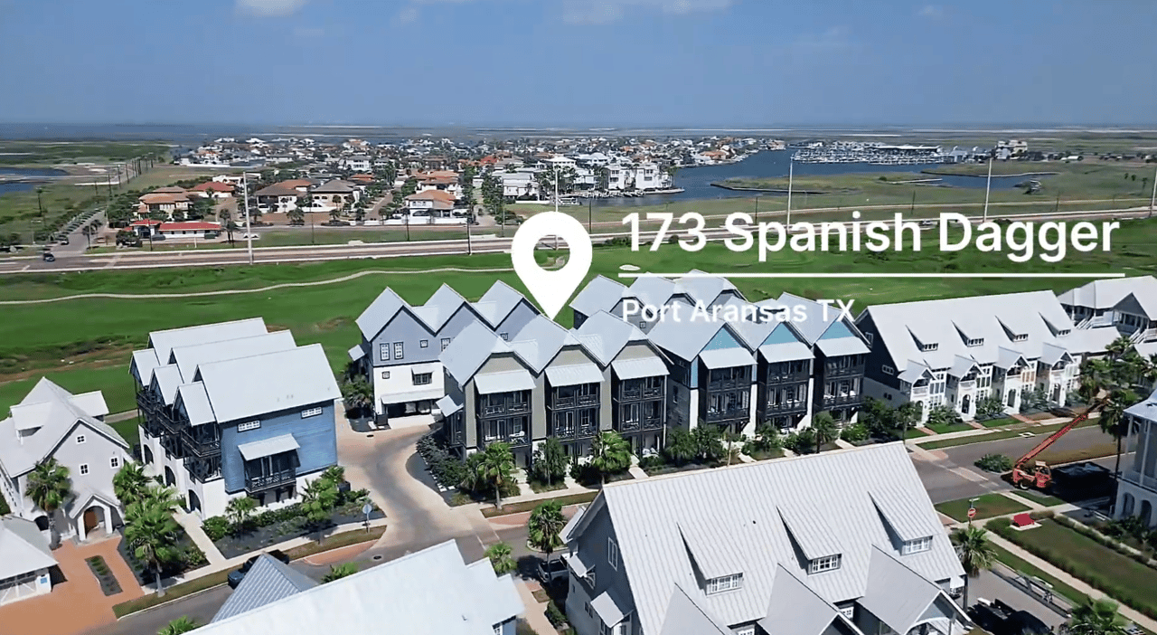 Aerial view of 173 Spanish Dagger townhomes near a coastal inlet in Port Aransas.