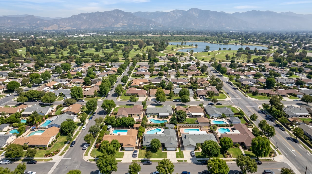 Aerial view of single-family ranch homes with backyard pools and mature trees in a residential San Fernando Valley neighborhood in the 91406 zip code