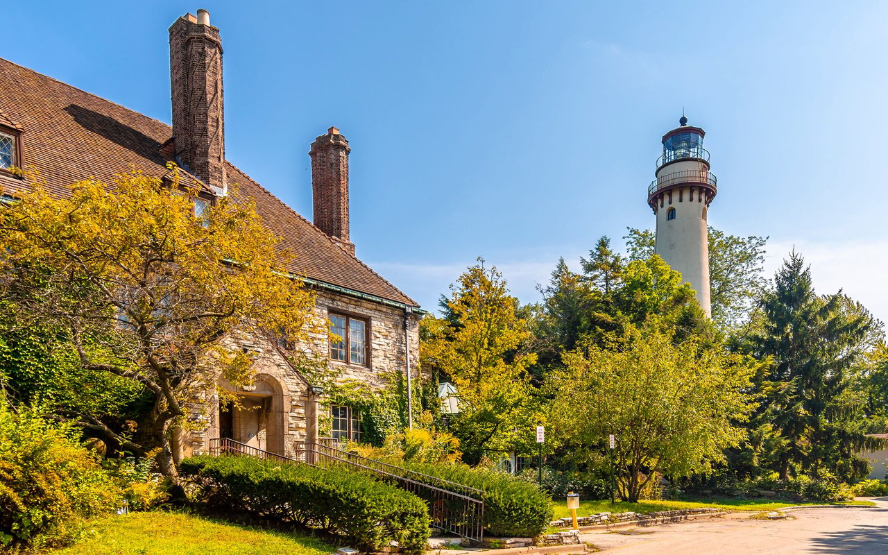 Stone building and autumn trees with a lighthouse in Evanston.