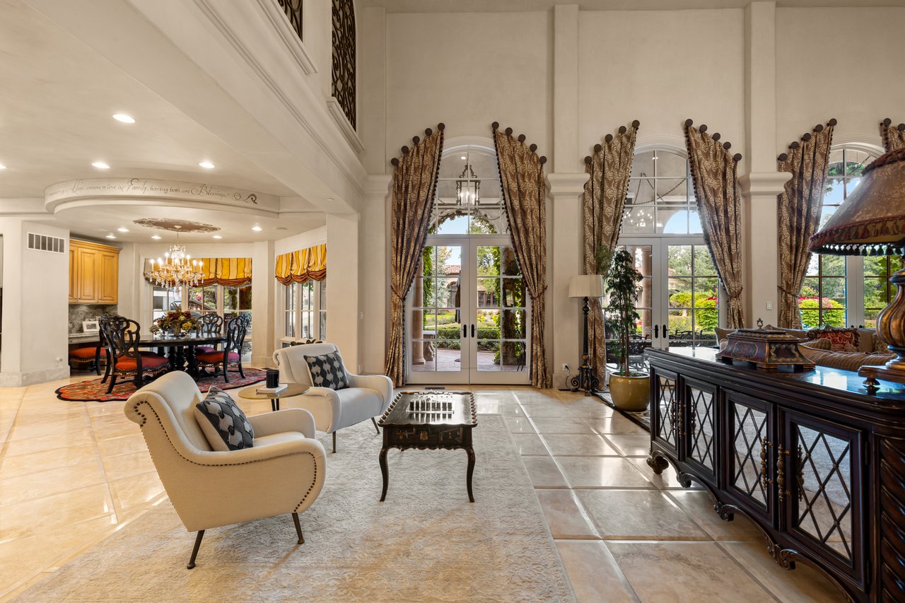 Living room with tall arched windows, French doors, and an adjoining dining area.