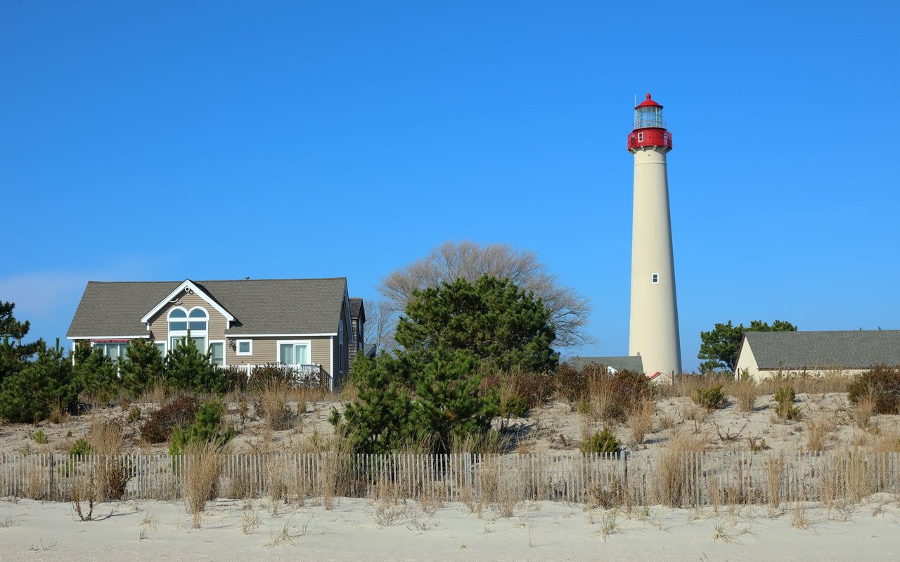 Cape May Point lighthouse rises above beach houses and sandy dunes.