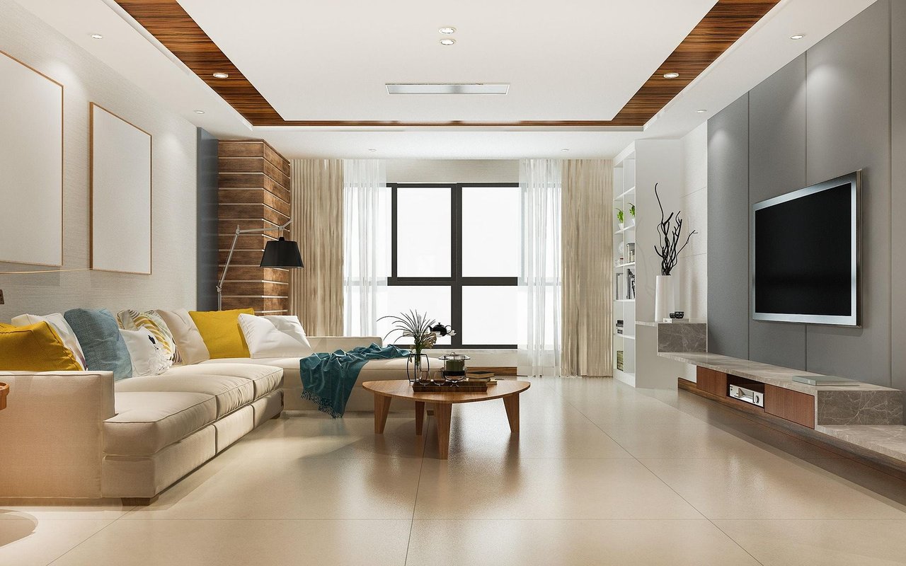 Modern living room with a cream sectional, wood coffee table, and wall-mounted television.