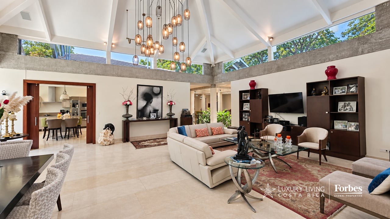 Furnished living room with a vaulted ceiling, clerestory windows, and a cream sectional sofa.