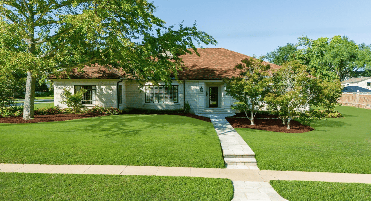 house with red tile roof and green grass