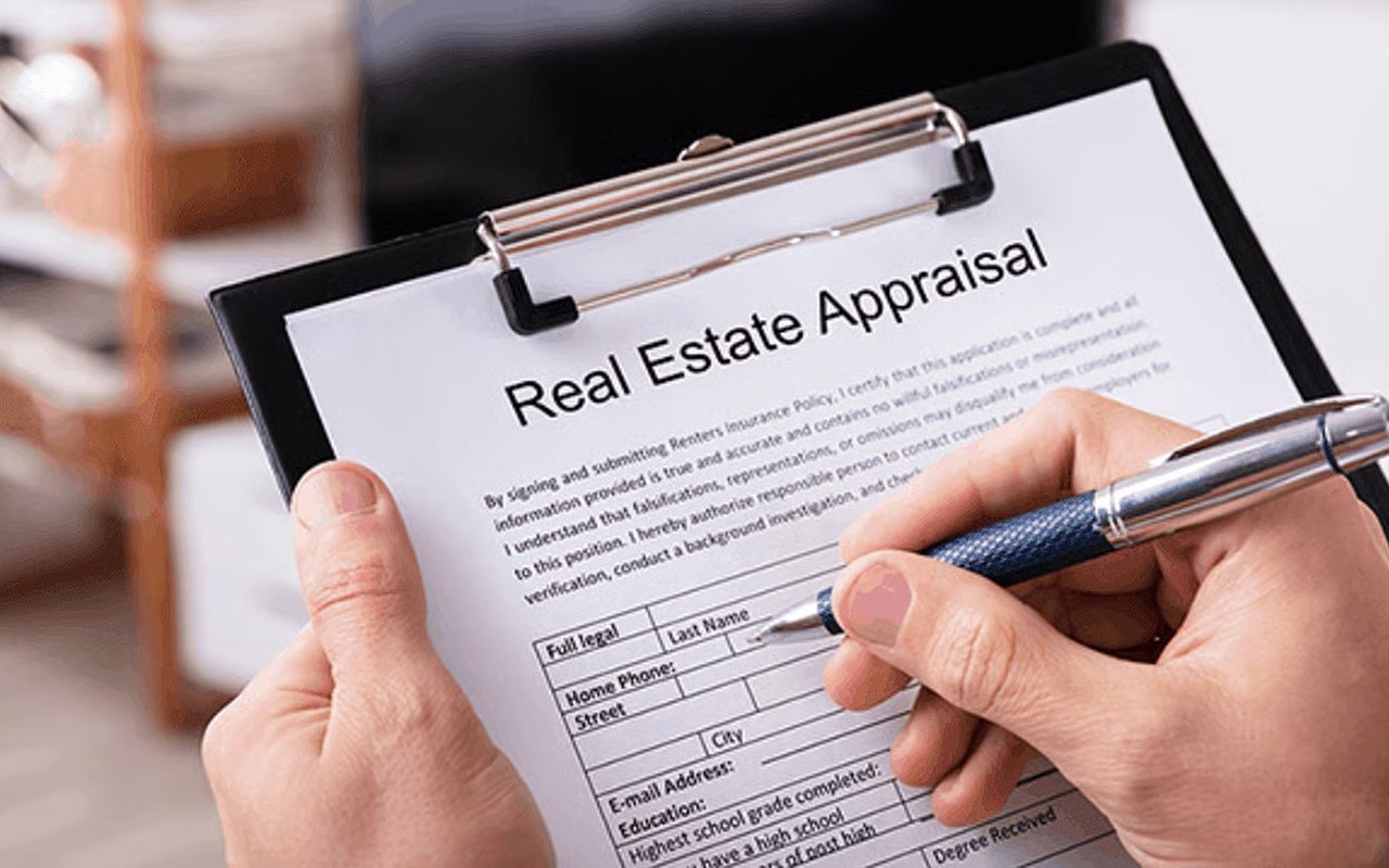 Hands complete a real estate appraisal form on a clipboard.