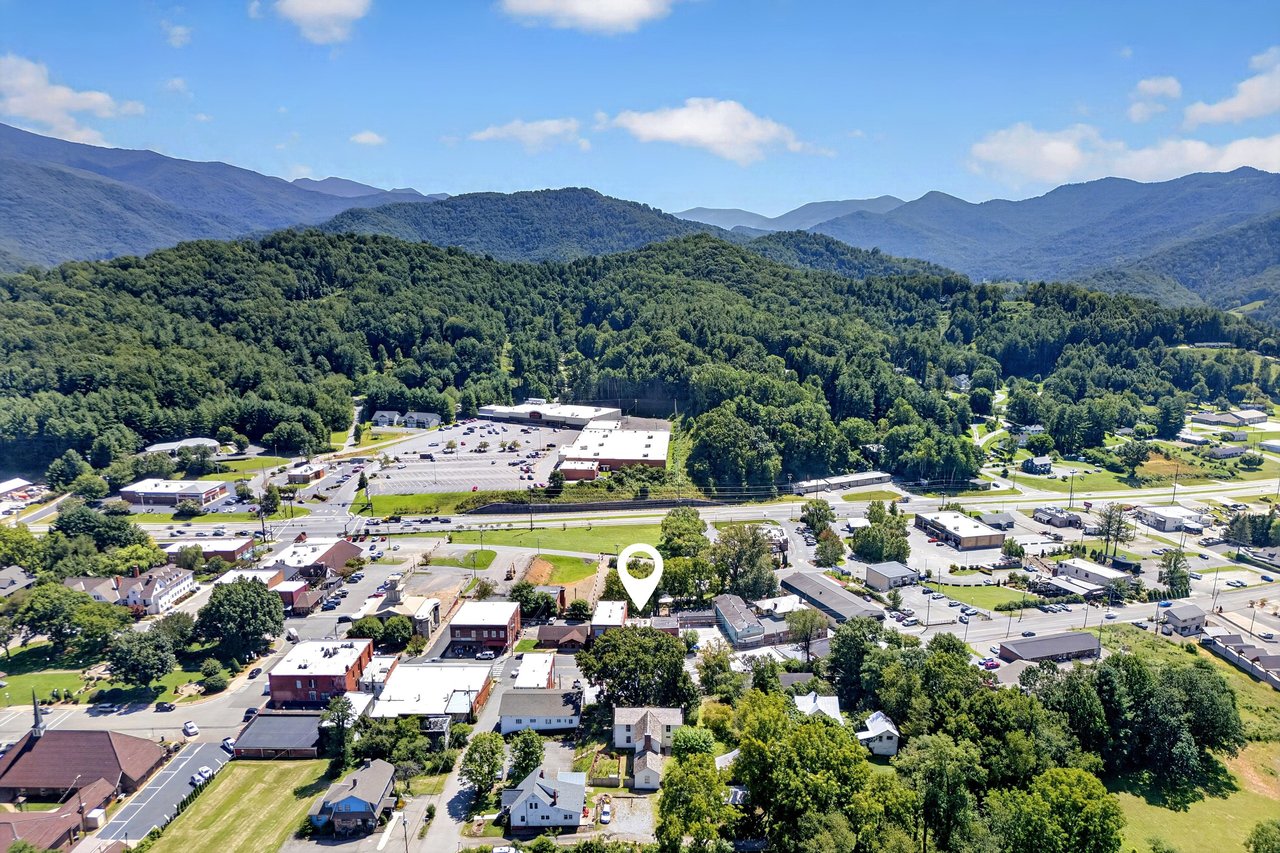 Aerial view of a small mountain town, with a map pin marking the property.