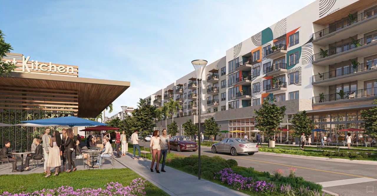Contemporary apartment building with colorful balconies above a landscaped pedestrian plaza and outdoor café.