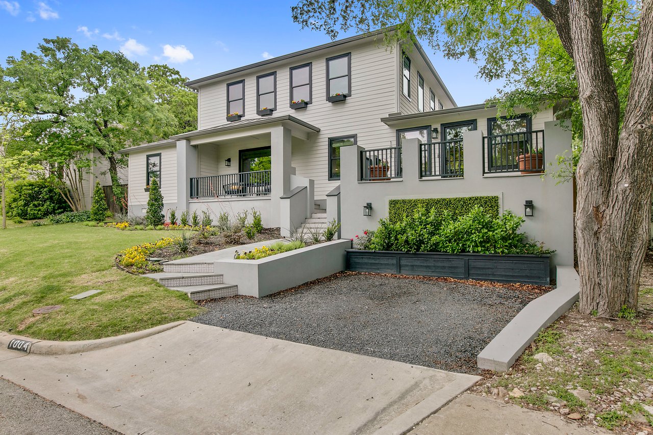 Front elevation of 1004 Maufrais Street in Clarksville (Old West Austin), Austin, TX, a two-story home with a covered front porch and light gray lap siding, architecture and construction by Greg Jacobson.