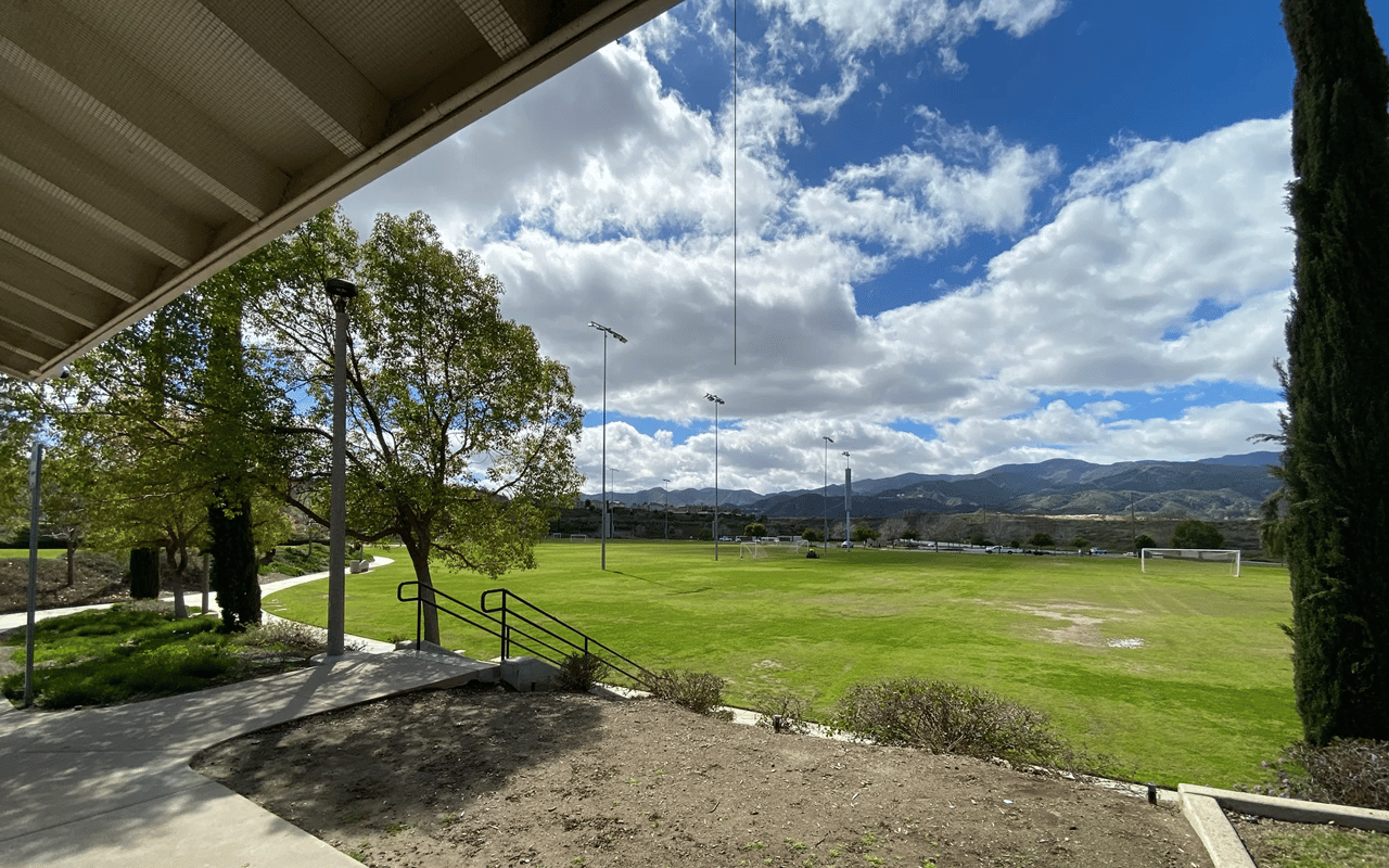 Lush green neighborhood park with walking paths and trees in Lake Elsinore, CA.
