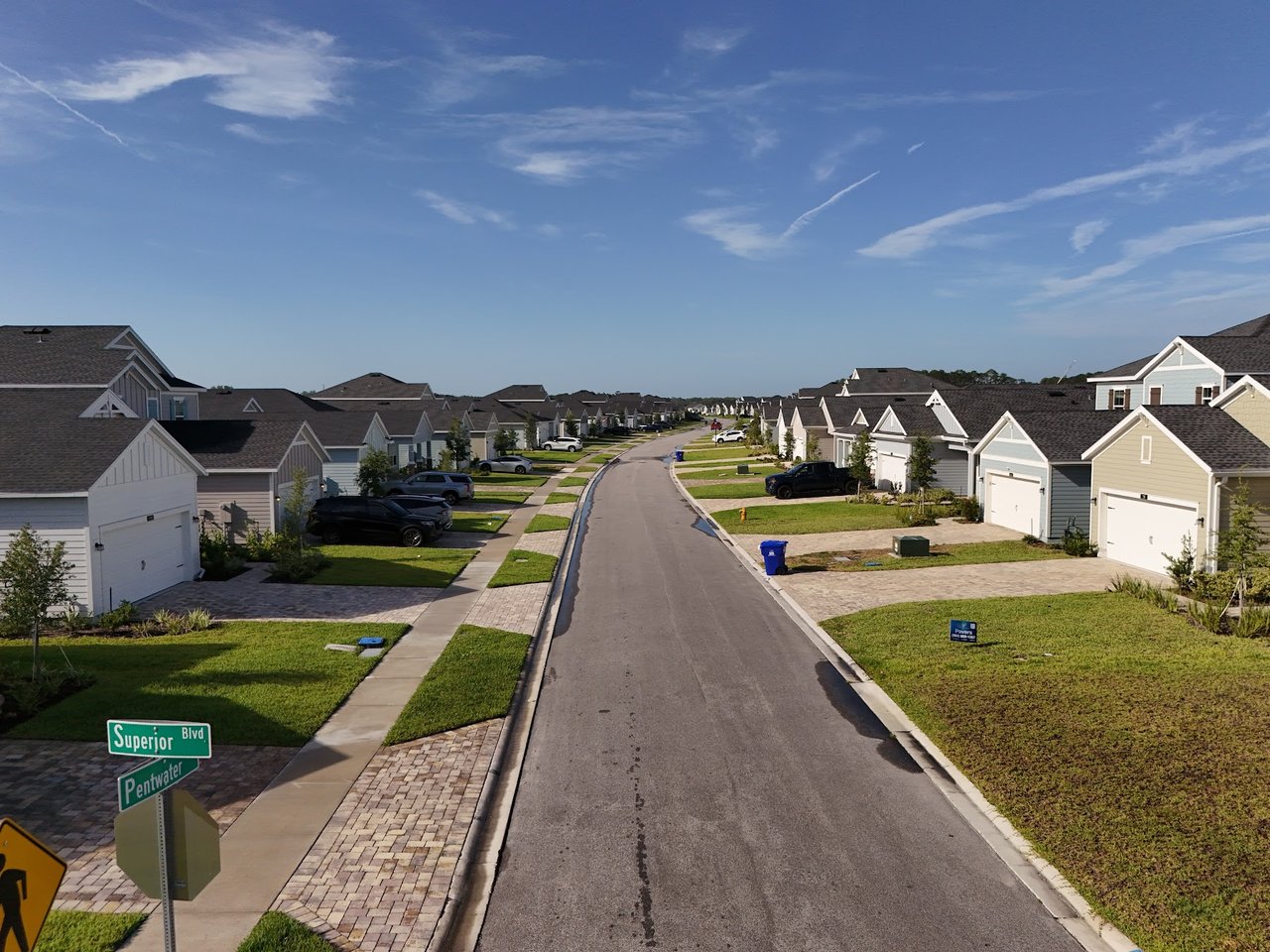 Residential street lined with modern homes and lawns; Superior Blvd and Pentwater signs mark the corner.