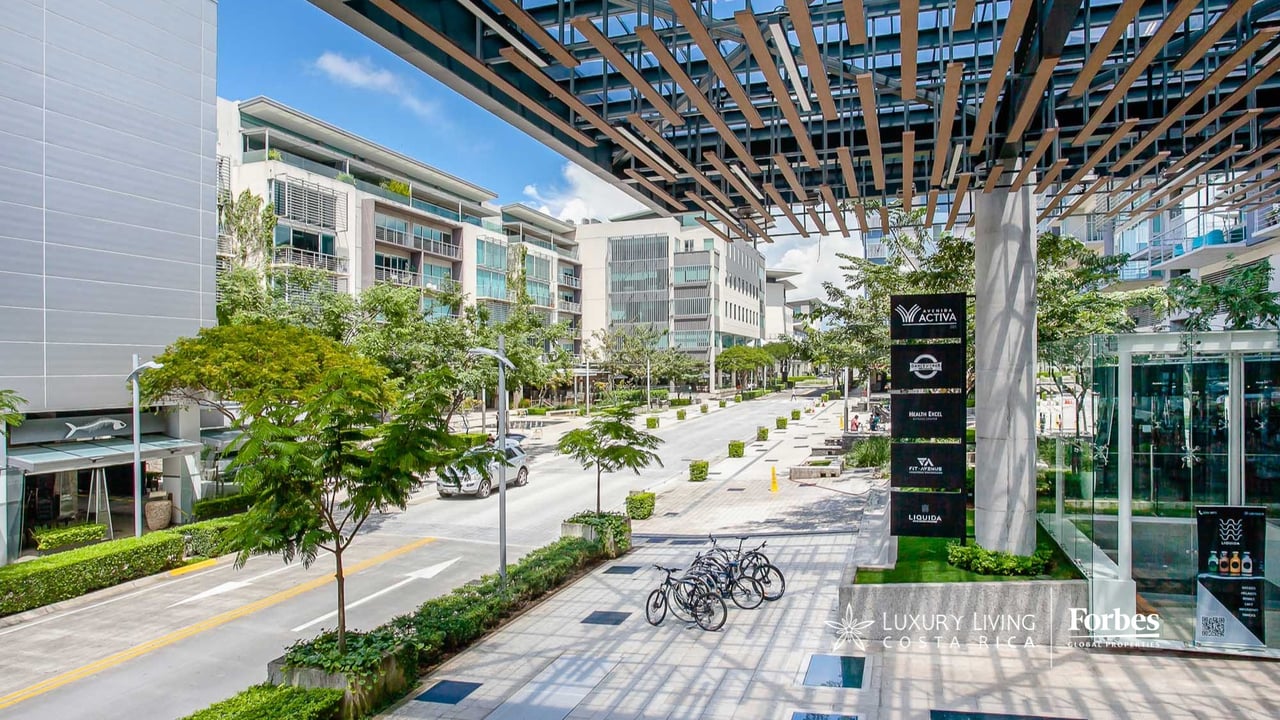 Avenida Escazú’s modern plaza with apartment buildings, landscaped walkways, and a timber canopy.