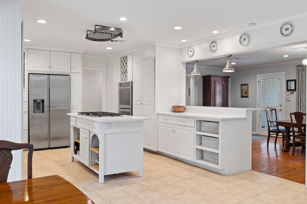 Kitchen with a center island, quartzite countertops, and stainless steel appliances at this mid-century modern home, 2404 Westover Rd, Tarrytown.