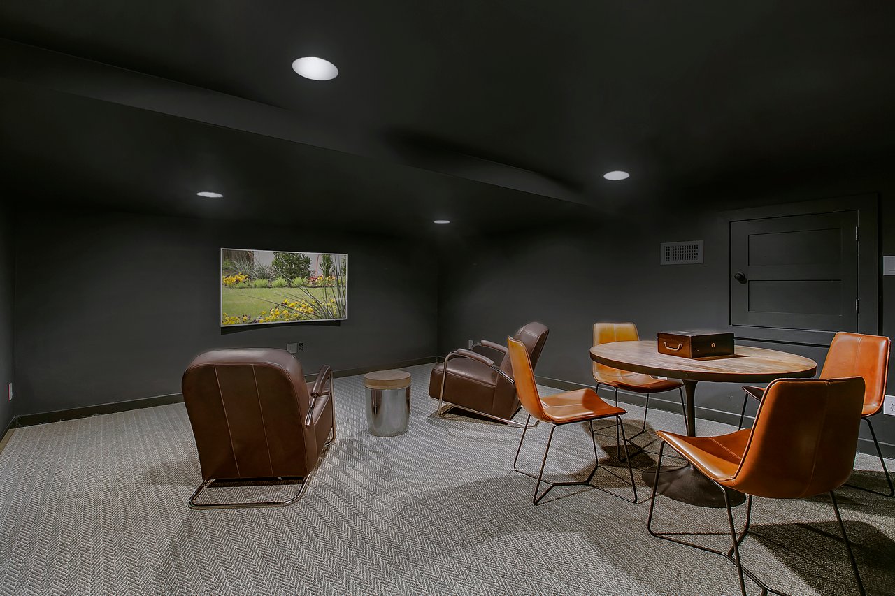 Flex room at 1004 Maufrais Street in Clarksville (Old West Austin), Austin, TX, with charcoal walls, patterned carpet, and leather lounge seating around a round table.