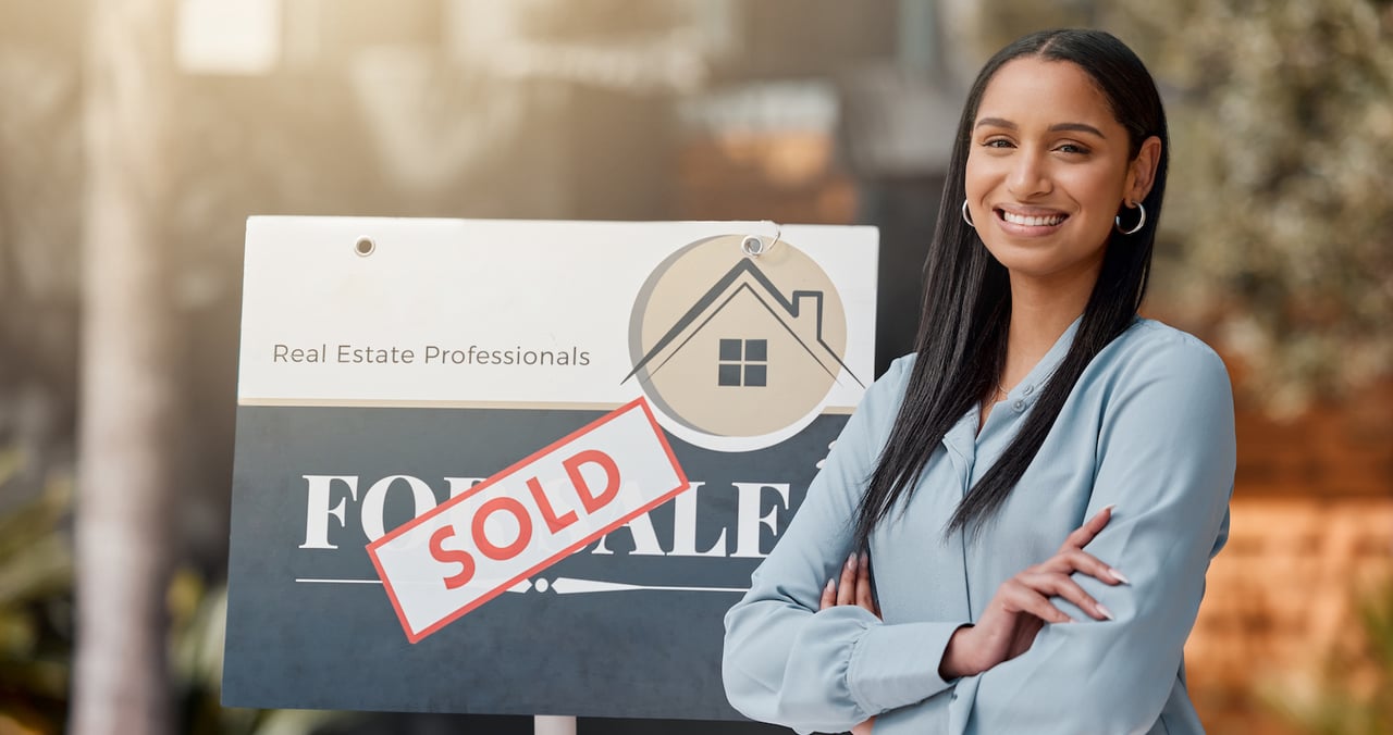 Real Estate Agent in Front of Sold Sign