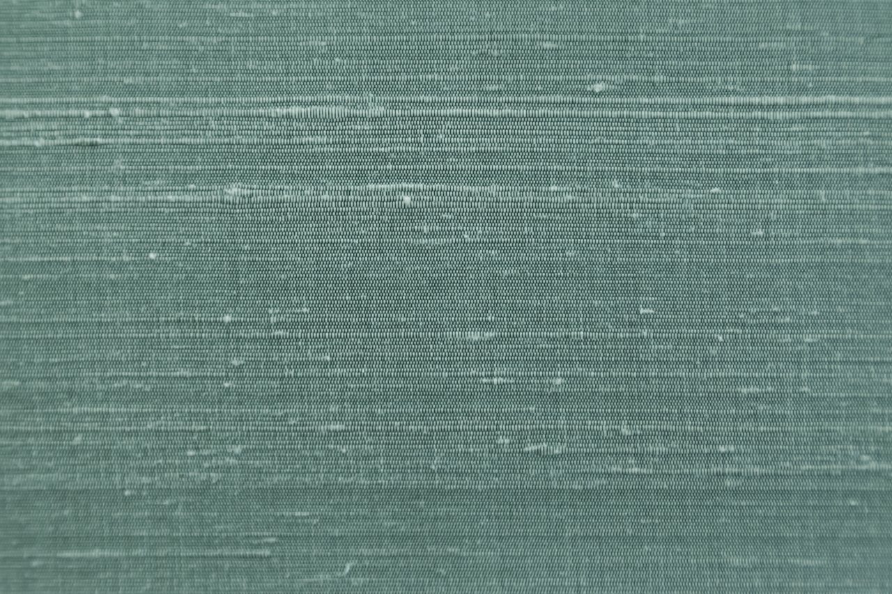 Mottled teal-green woven fabric with a fine horizontal weave.