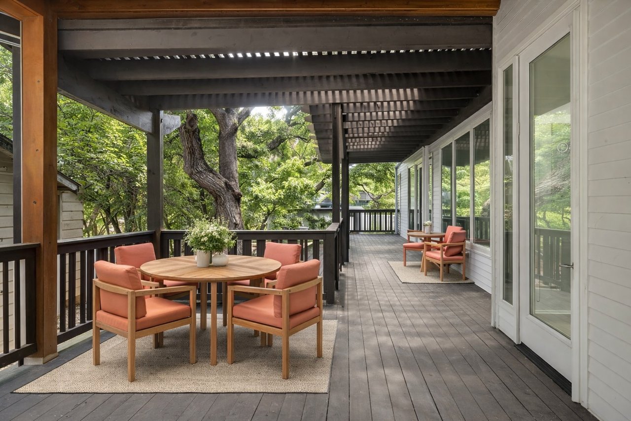 Wrap-around screened deck at 1302 S 5th St Unit A, Bouldin, Austin, TX, with a wood pergola roof, outdoor dining table, and a mature oak tree.