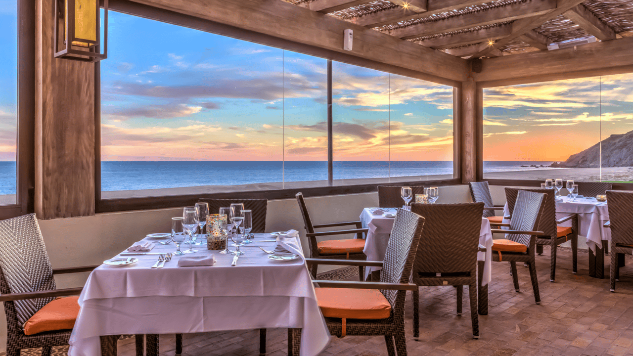 Oceanfront dining room set for dinner at sunset at Quivira