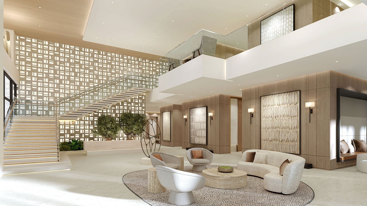 Condominium lobby with a sculptural staircase, patterned screen wall, and contemporary lounge seating.