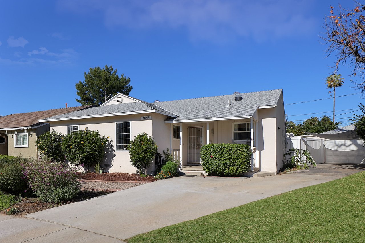 Angled view of well-maintained Lake Balboa home with manicured landscaping and private driveway