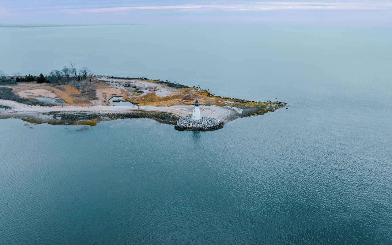 Bridgeport shoreline with a white lighthouse on a rocky point.