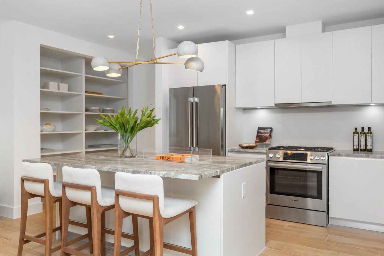 Arbor Coconut Grove residence kitchen with white cabinetry and breakfast bar