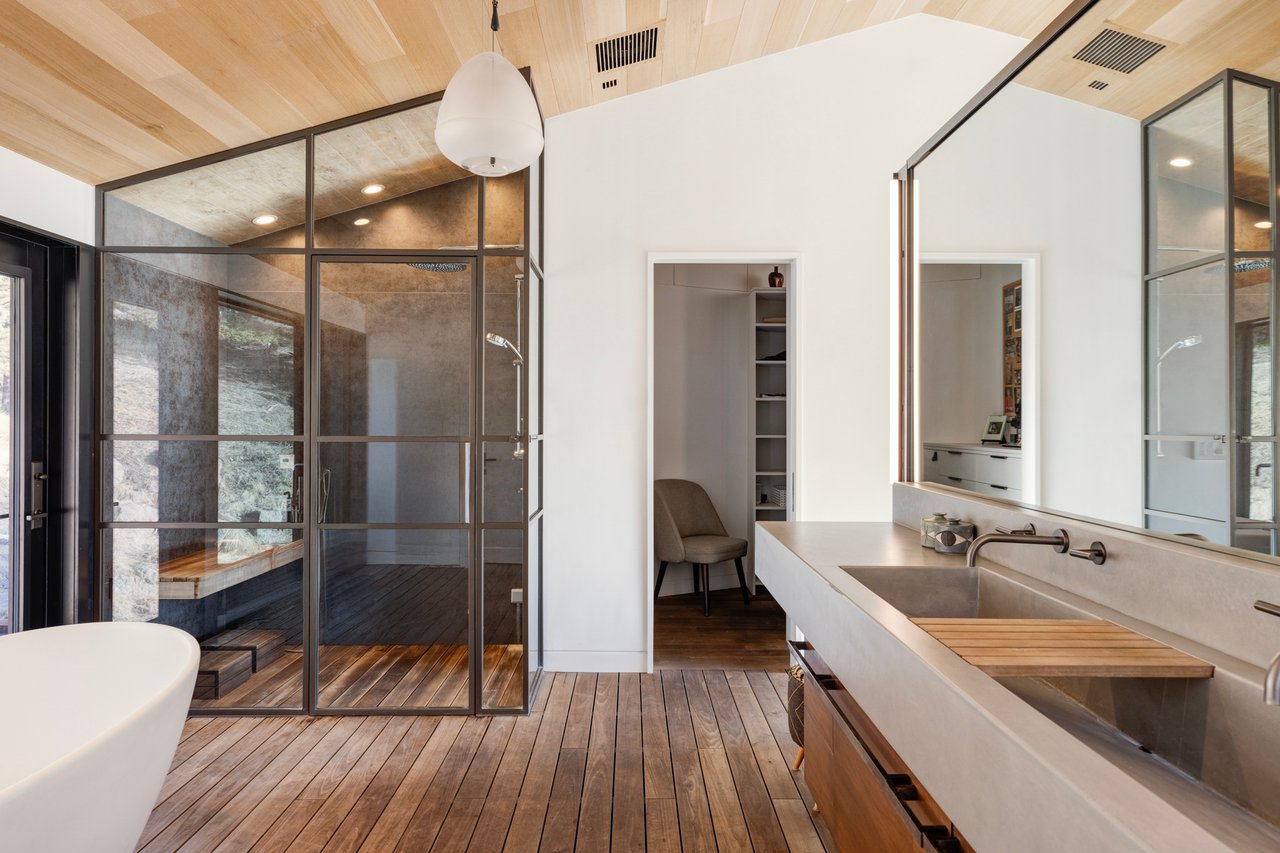Modern Boulder bathroom featuring wood flooring, double vanity, and glass-enclosed shower with mountain views