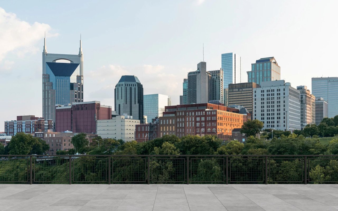 Nashville skyline beyond trees, viewed from a paved terrace.
