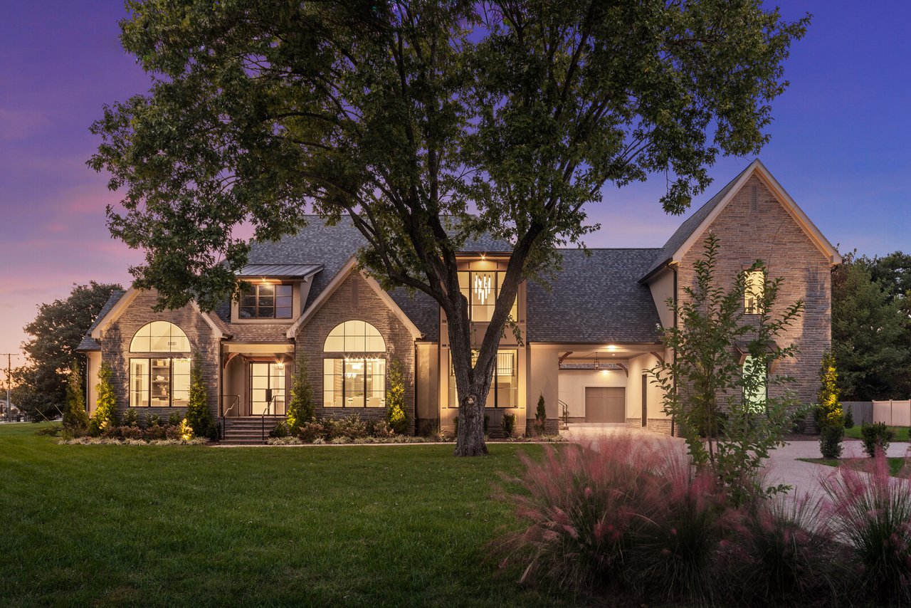 Front exterior of 521 Mansion Dr, Brentwood — stone gables and warm lighting at dusk