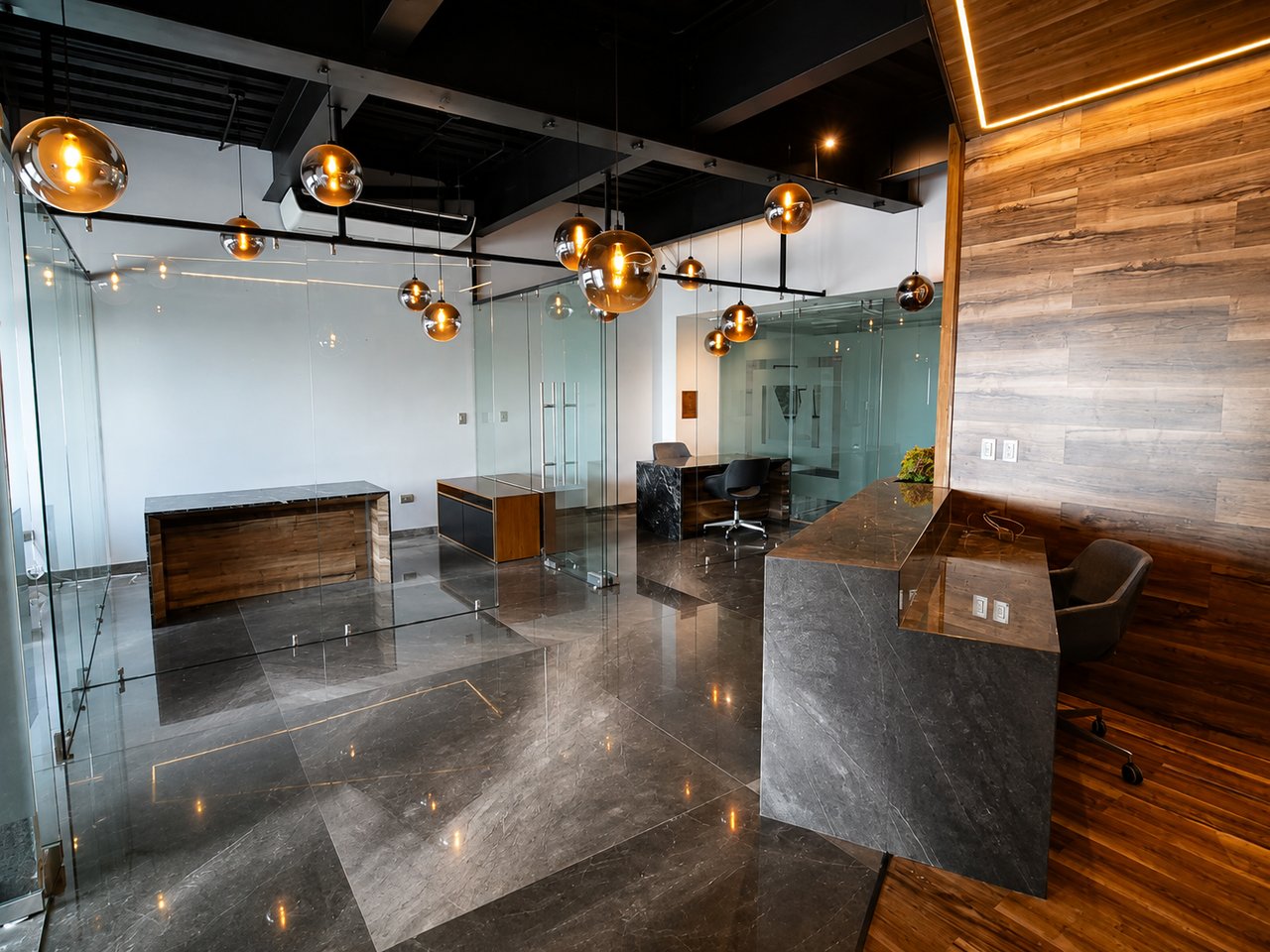Corporate office reception with glass partitions, stone floors, and a wood accent wall.
