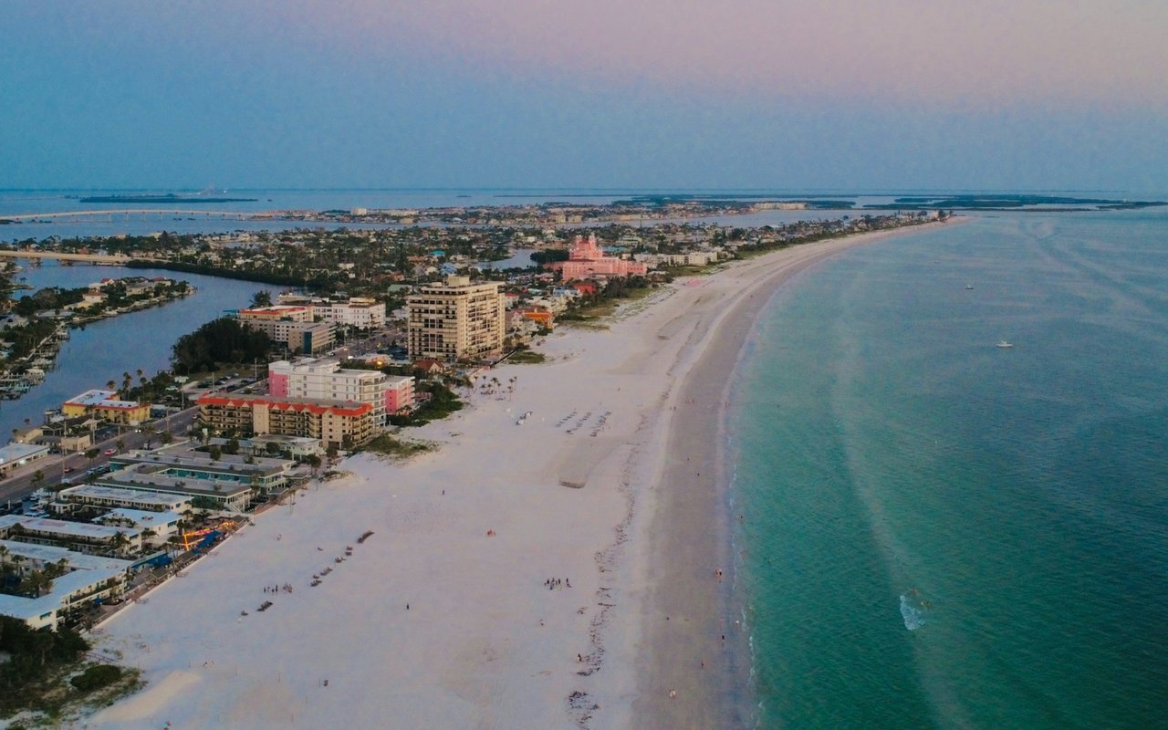 Aerial view of Manatí’s sandy shoreline, turquoise water, and coastal buildings.
