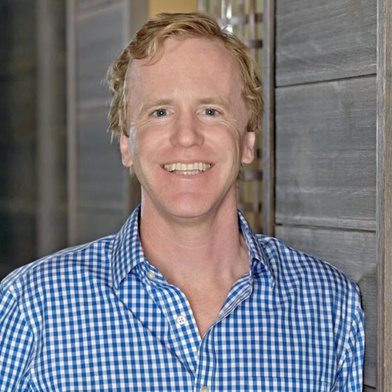 Ian Scott Mullin smiling in a blue-and-white checkered shirt.
