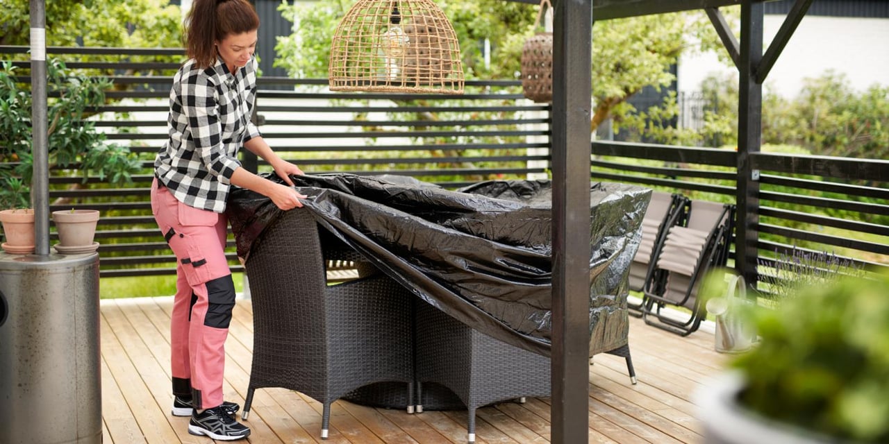 Homeowner securing patio furniture and outdoor items before a hurricane in Florida