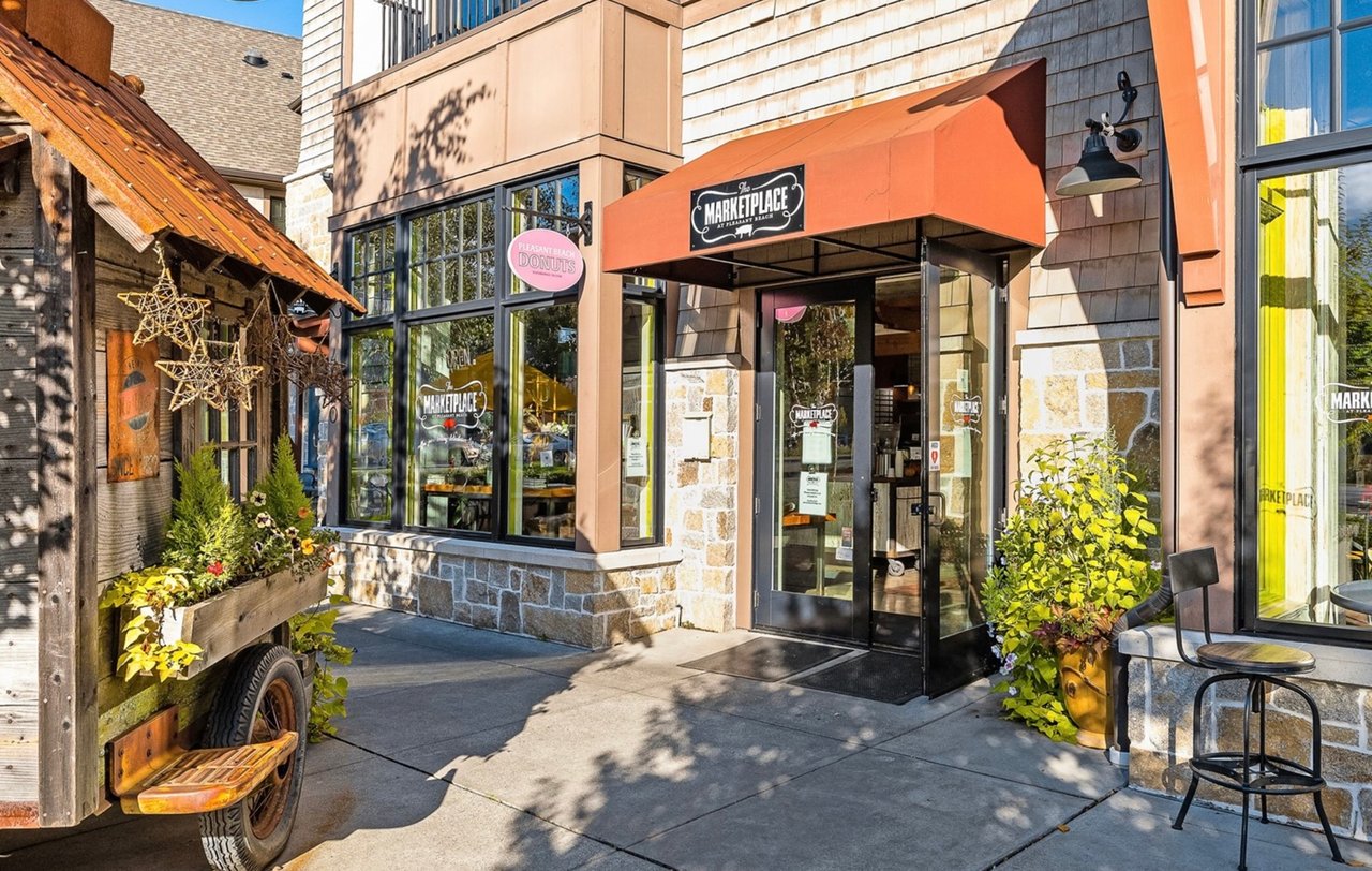 The Marketplace storefront with an orange awning, stone facade, and outdoor seating.
