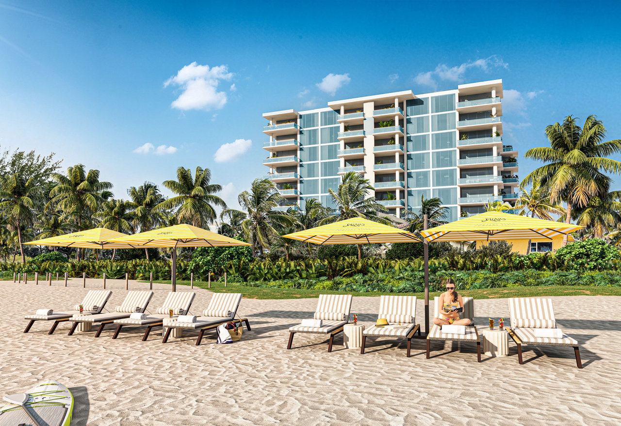 Salato Residences beachfront condominium behind palm trees and striped umbrellas on a sandy beach.