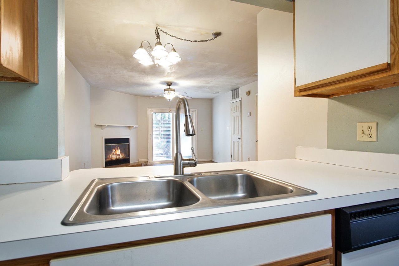 A modern kitchen featuring a sink and a stove top, showcasing a clean and functional design.