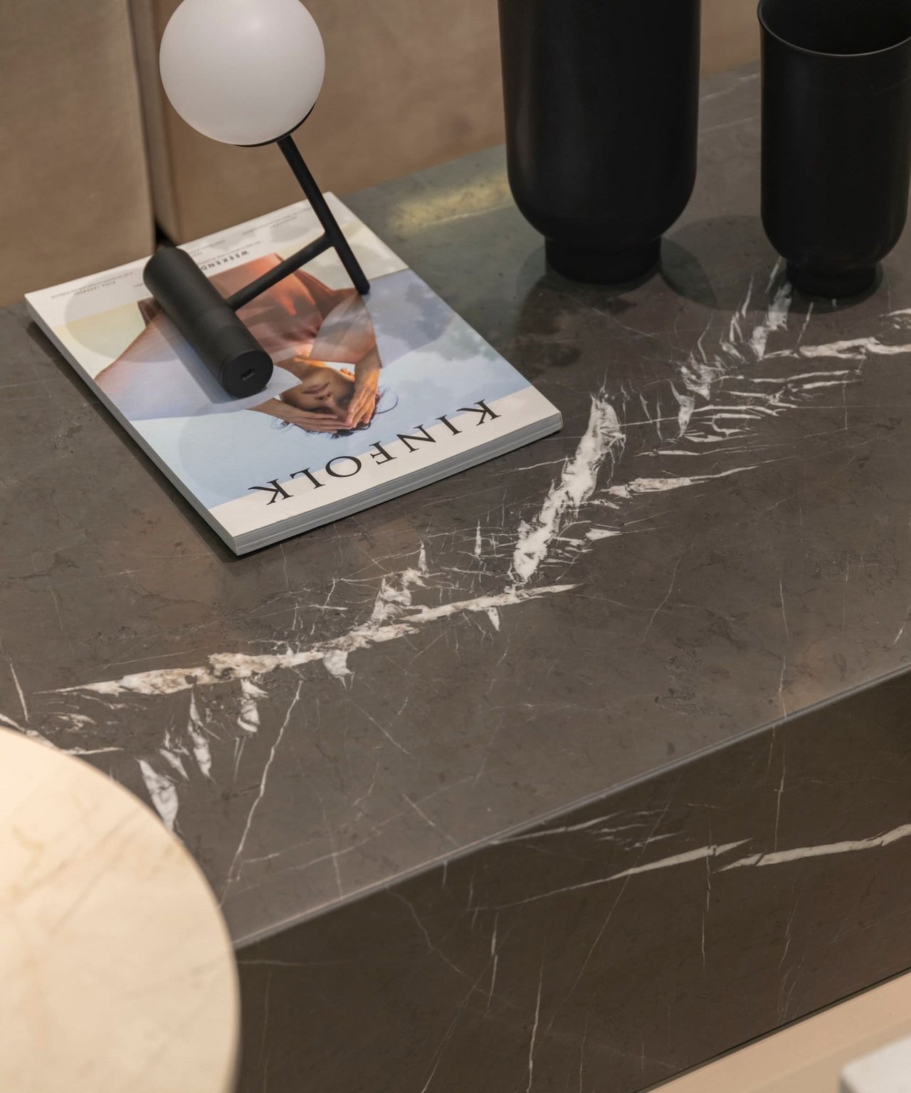 Marble countertop styled with a Kinfolk magazine, globe lamp, and black vases.