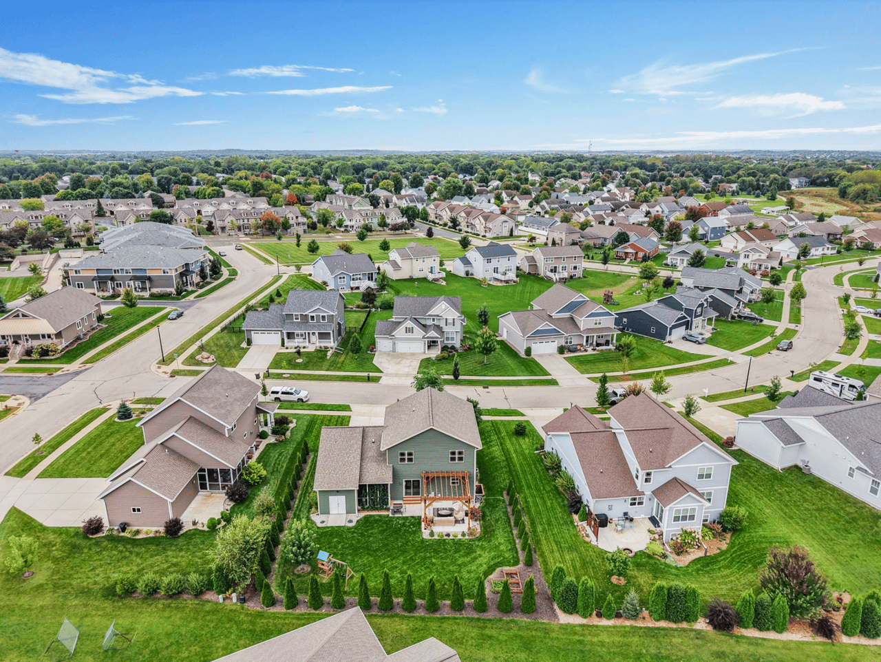 An aerial view of a family-friendly neighborhood in the Greater Madison area, featuring modern single-family homes and green spaces, ideal for first-time homebuyers looking for value and community in 2026.