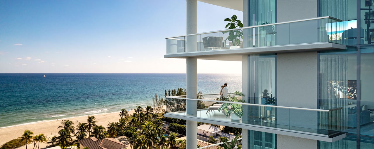 Beachfront condominium with glass balconies overlooking the ocean and a palm-lined sandy beach.