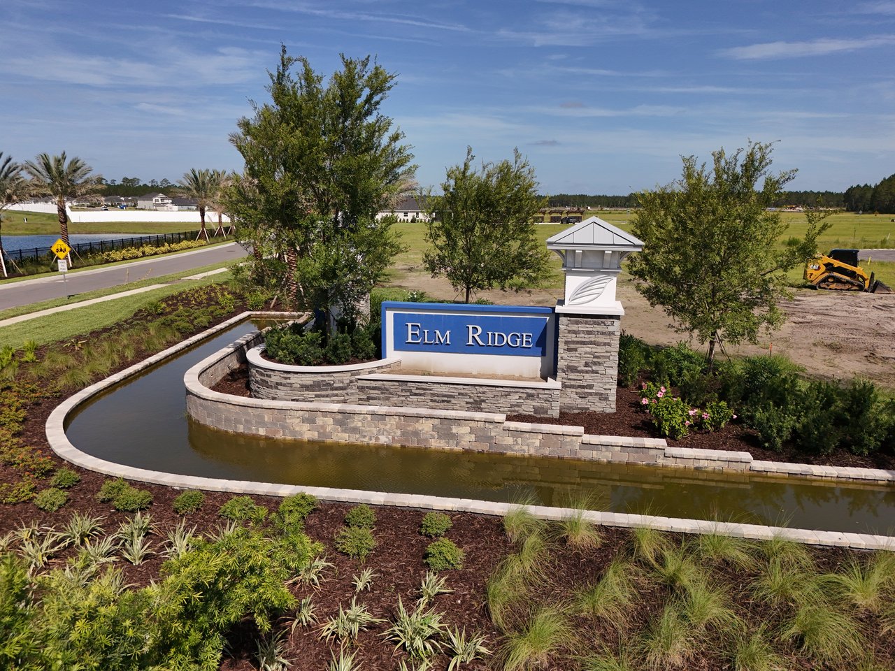 Elm Ridge community entrance sign beside a landscaped water feature.