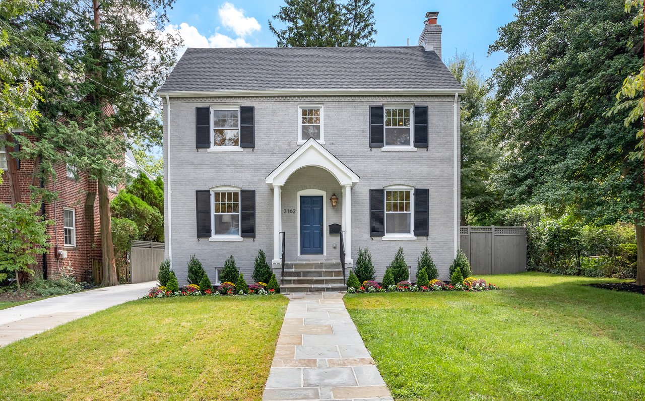 Luxury colonial-style home in Upper Northwest Washington DC with brick exterior and navy front door