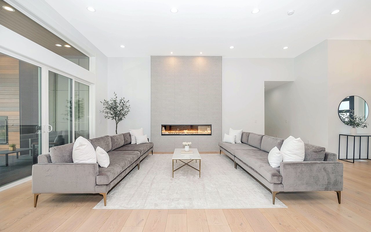 Contemporary living room with facing gray sofas and a linear fireplace.