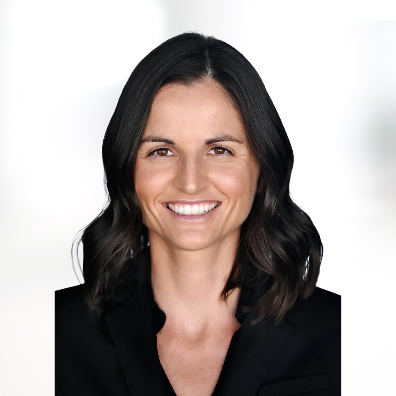 Whitney Spatz smiling in a black blazer against a white background.
