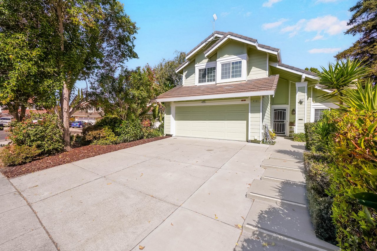 Two-story home with a two-car garage, wide driveway, and landscaped entry.