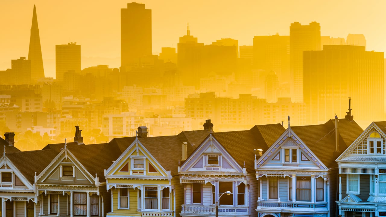 Colorful Victorian houses with the San Francisco skyline in the background