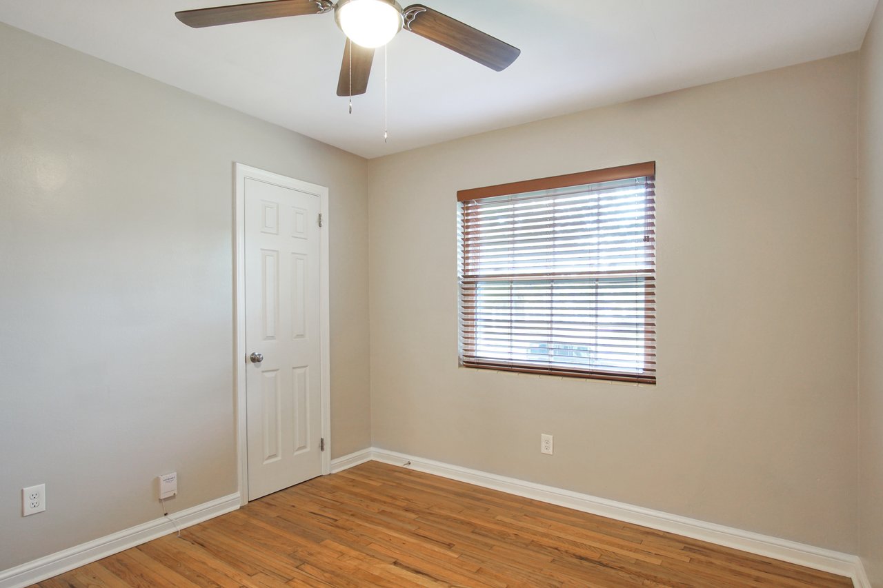 A room featuring a ceiling fan and elegant hardwood floors, creating a warm and inviting atmosphere.