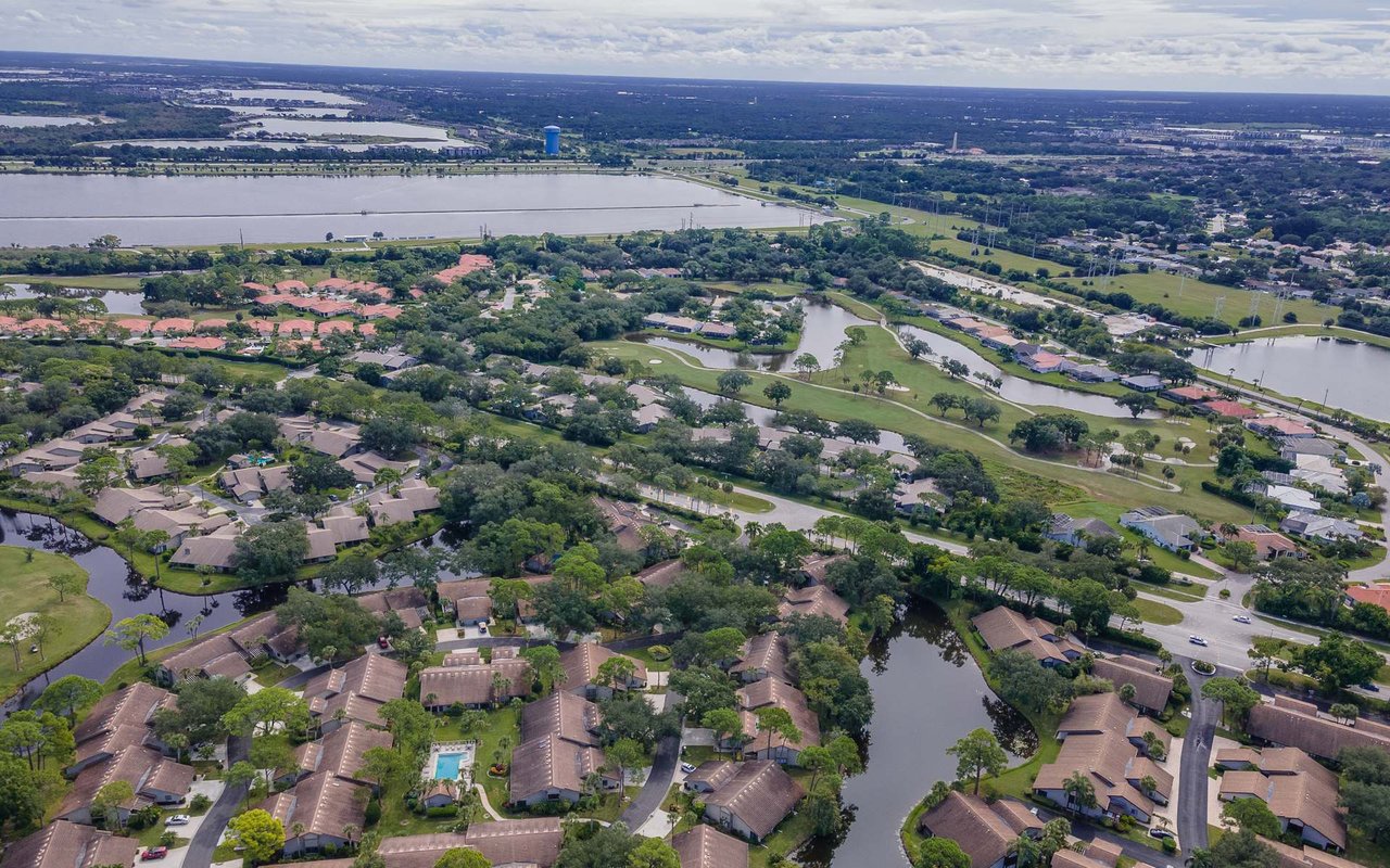 Aerial view of The Meadows with homes, golf course fairways, and ponds.