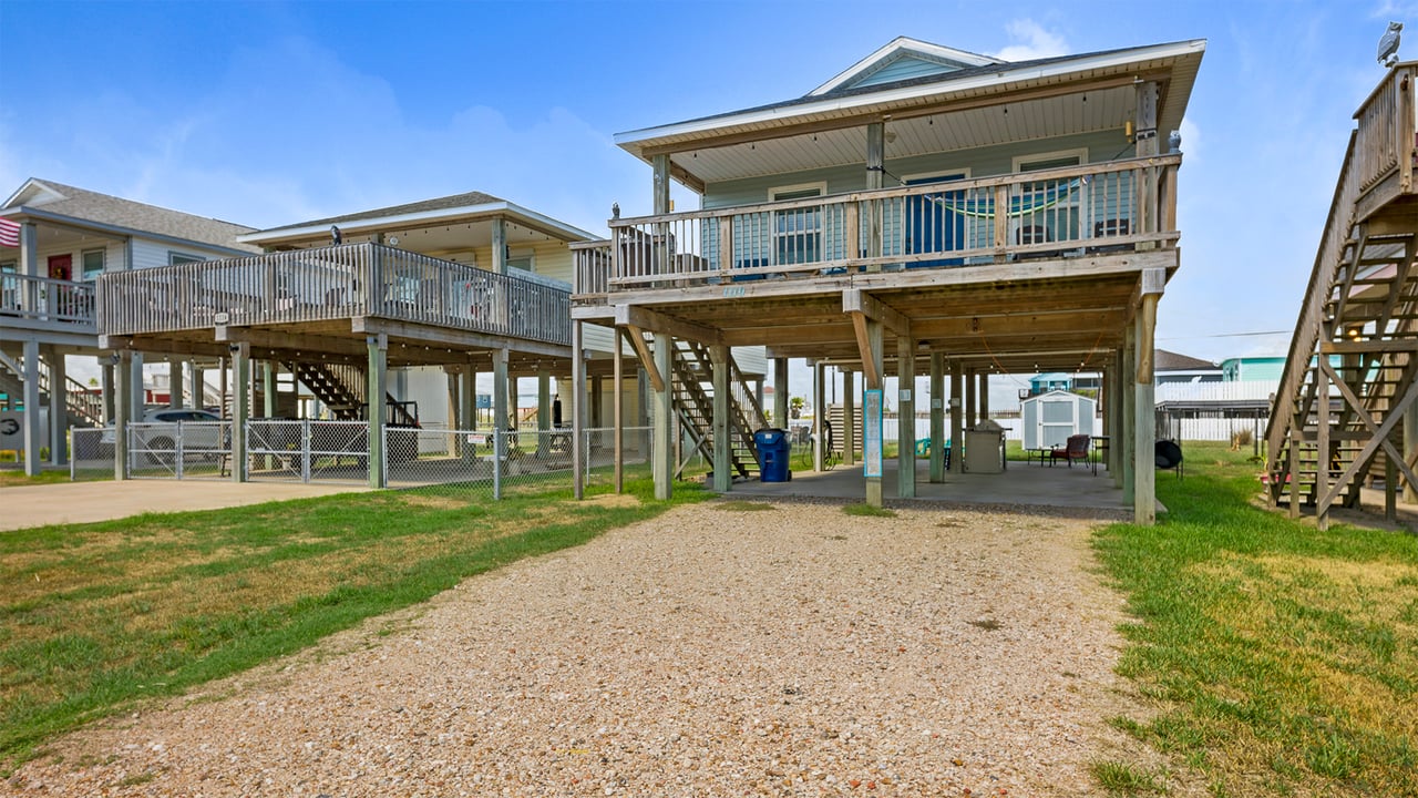Coastal Charm at 1110 Treaty Drive with its light blue exterior vinyl siding and outdoor kitchen.