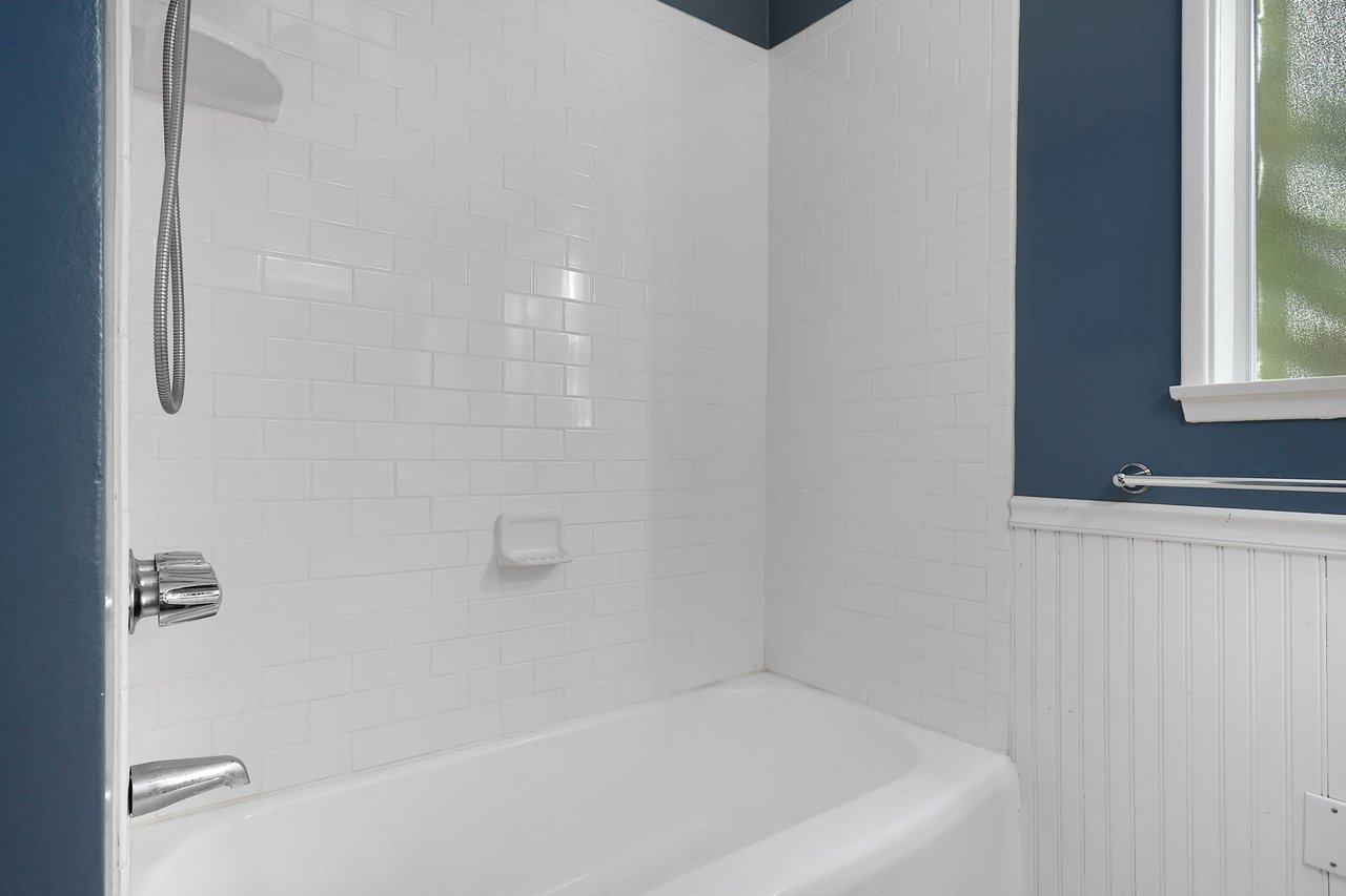 Clean white bathtub with polished subway tile surround in Lake Balboa secondary bathroom