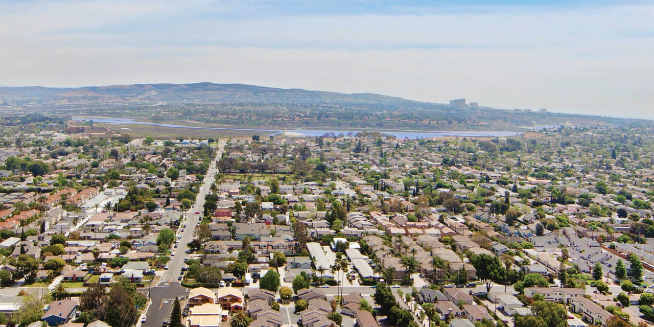 Aerial view of Eastside Costa Mesa neighborhood with tree-lined streets and homes.